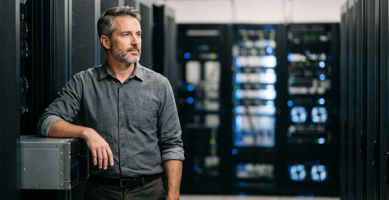 Administrateur informatique inspectant avec attention un serveur d'entreprise dans une salle technique sobre